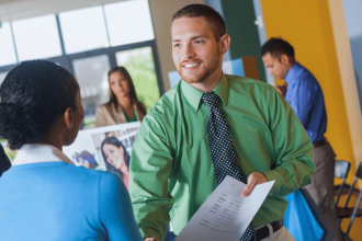 Employeur discutant avec des candidats lors d'un salon de l'emploi